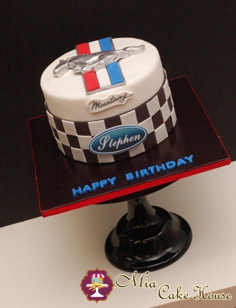 a birthday cake that is sitting on top of a table in front of a black and white background