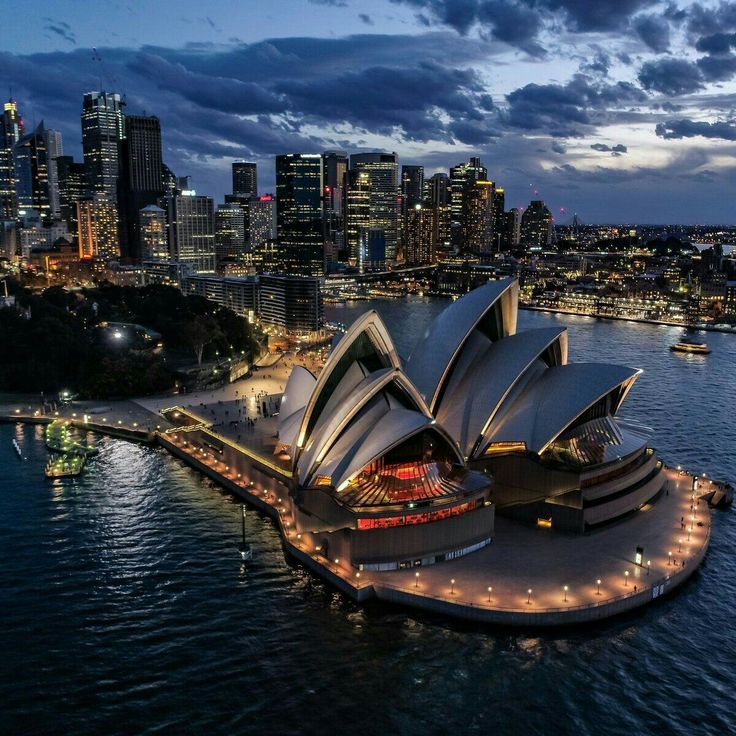 the sydney opera is lit up at night