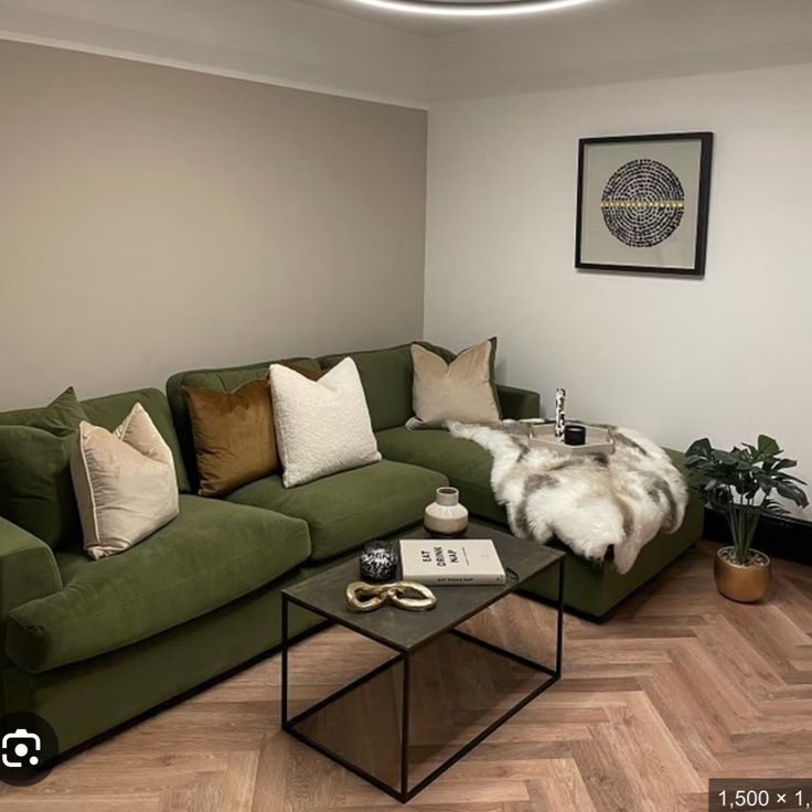 a living room with green couches and pillows