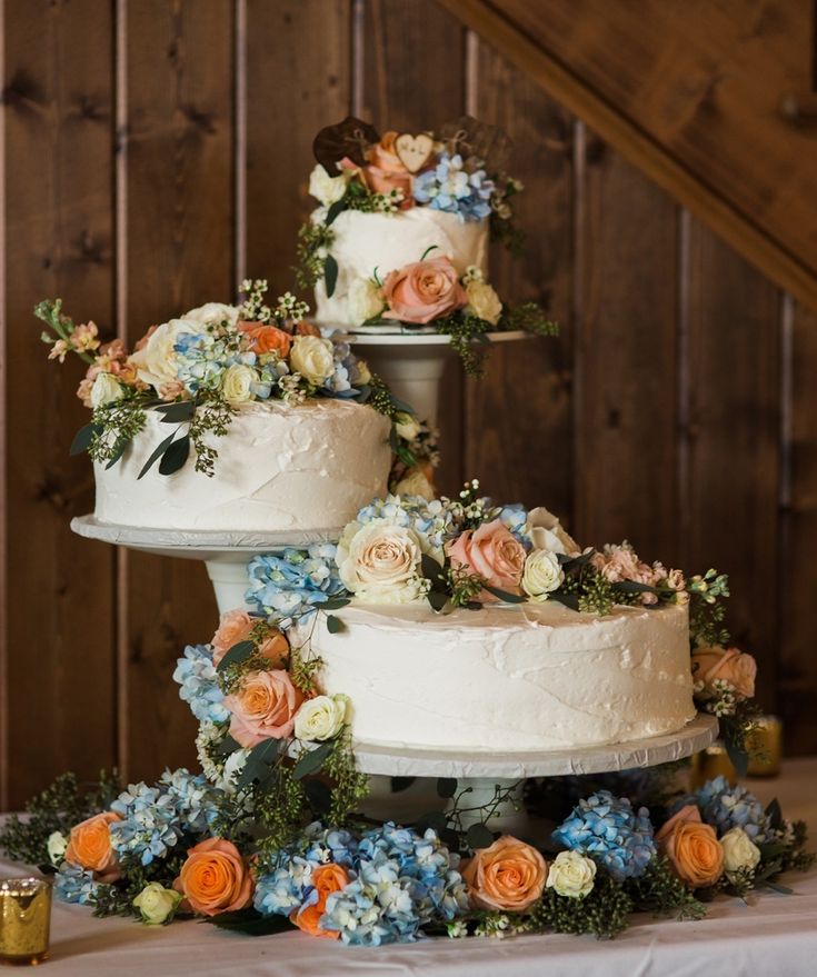 three tiered wedding cake with flowers and greenery