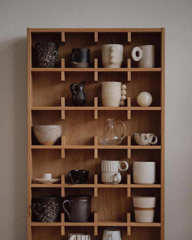 a wooden shelf filled with lots of cups and saucers