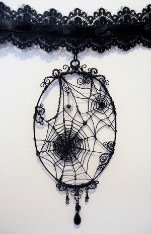 a spider web hanging on the wall next to a black lace choker with beads