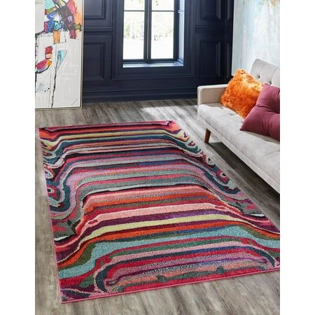 a multicolored rug in a living room next to a couch and window with a painting on the wall