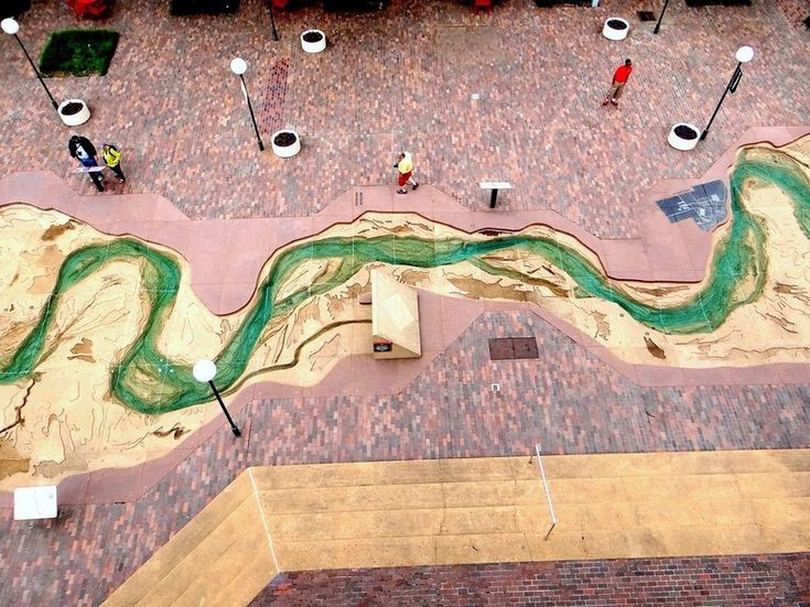 an aerial view of a skateboard park with ramps and people walking on the walkway