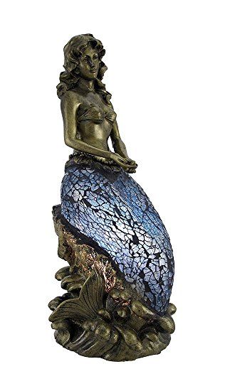 a mermaid statue sitting on top of a blue ball