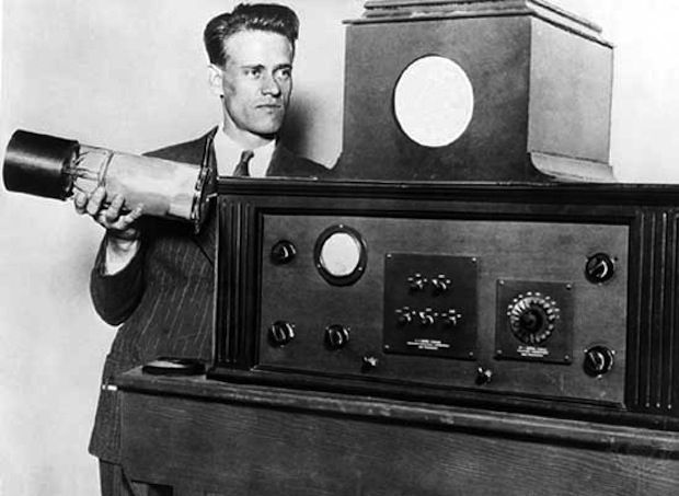 a man in a suit holding an old fashioned radio and looking at the clock on it