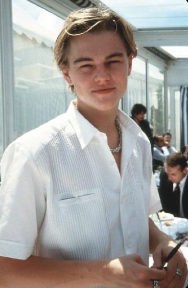 a man in white shirt holding a pen and writing on paper next to other people