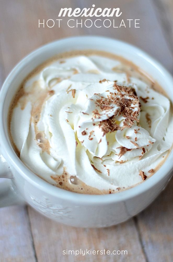 a white cup filled with whipped cream on top of a wooden table