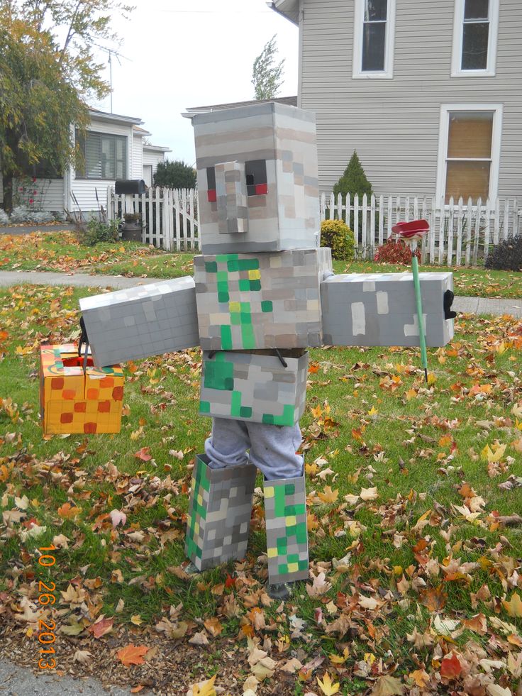 a man made out of lego blocks standing in the grass