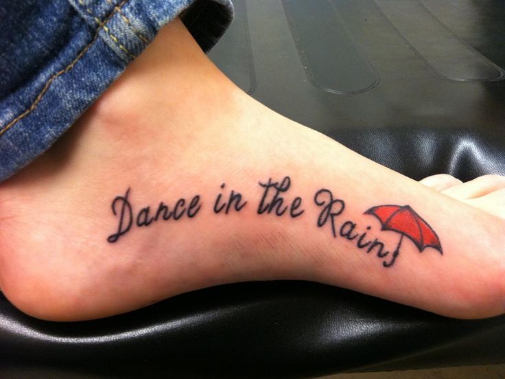 a person with a tattoo on their foot that says dance in the rain