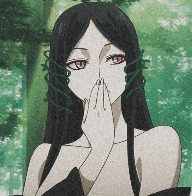 a woman with long black hair covering her mouth in front of some trees and grass