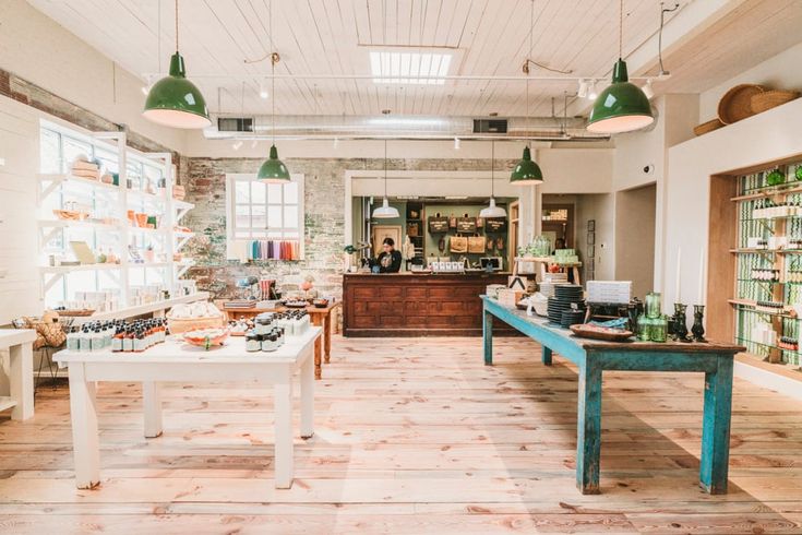 the inside of a store with lots of items on tables and lights hanging from the ceiling