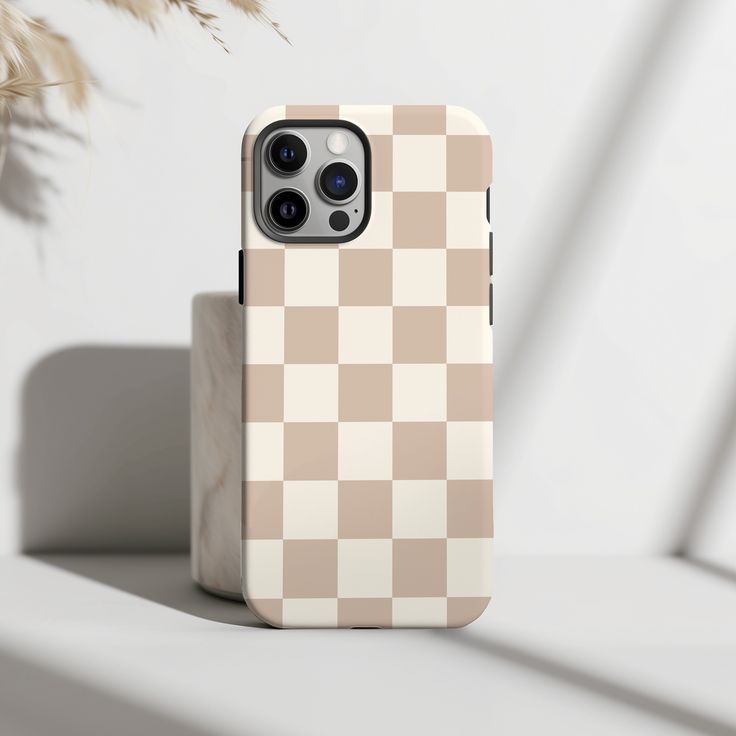 an iphone case sitting on top of a white table next to a potted plant