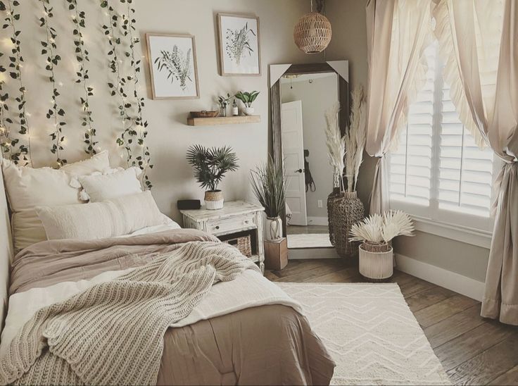 a bed room with a neatly made bed next to a window covered in curtains and plants