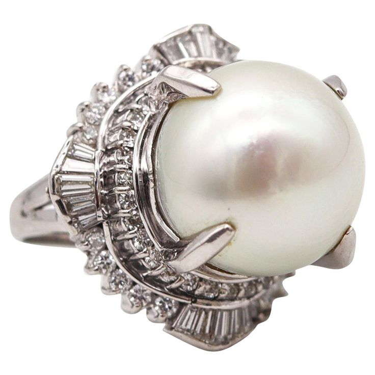 Cocktail ring with South-Seas pearl and diamonds. Beautiful cocktail ring mounted with an oversized white pearl from the South Seas. The fabulous ring and has been crafted with substantial classic design in solid platinum .900/.999 platinum with high polished finish. It is embellished with a great selection of seventy earth mined natural white diamonds diamonds and one white round pearl from the South Seas. Diamonds: Mounted in double prongs settings, with 50 round brilliant cut diamonds, 0.88 carats, white colorless F/G color, VS/SI clarity. Diamonds: Mounted in channel settings, with 20 tapered baguette cut diamonds, 0.83 carats, white colorless F/G color, VS-2 clarity. Pearl: Mount in the center in four-prongs settings, with 1 cultured South-Seas white pearl of 16.07 mm. The pearl is Gi Luxury Brilliant Cut Round Pearl Ring, Luxury Fine Jewelry Pearl Ring With Round Band, Luxury Pearl Anniversary Ring, Luxury Exquisite Pearl Ring With Prong Setting, Luxury Pearl White Diamond Engagement Ring, Luxury Multi-stone Pearl Ring For Anniversary, Luxury Brilliant Cut Pearl Ring In Sterling Silver, Luxury Pearl Cabochon Ring, Luxury Antique White Gold Pearl Ring