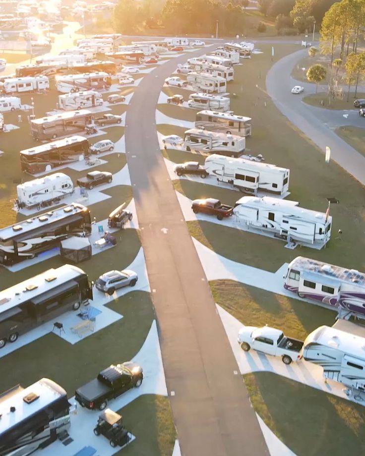 an aerial view of many recreational vehicles parked in a parking lot with the sun shining on them