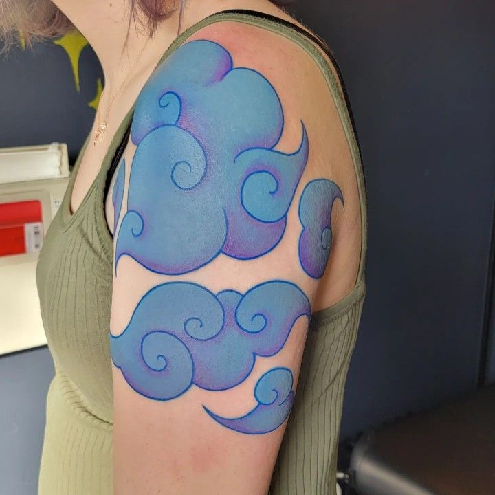 a woman with a blue cloud tattoo on her arm