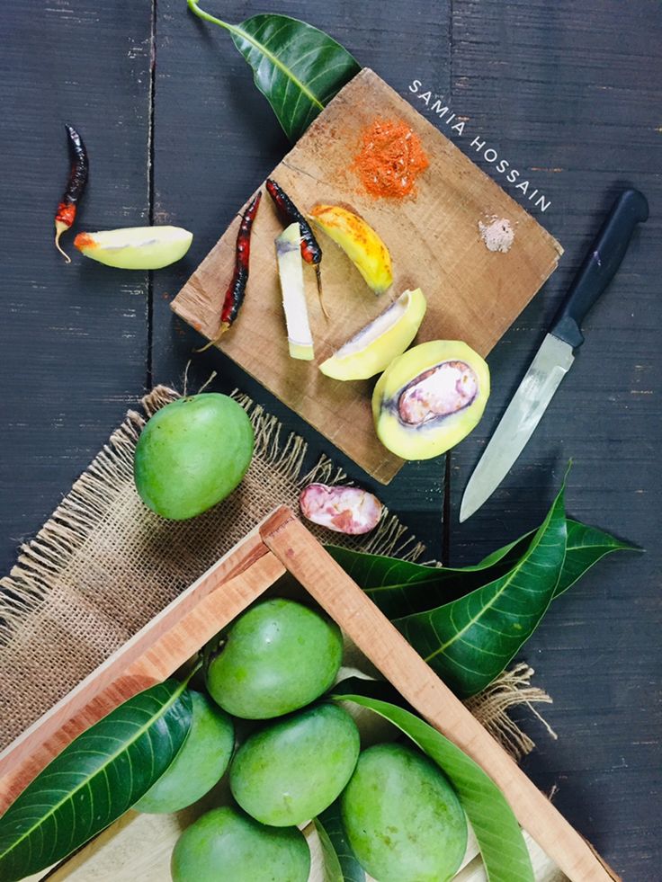 some fruit is laying on a cutting board next to a knife and chopping board