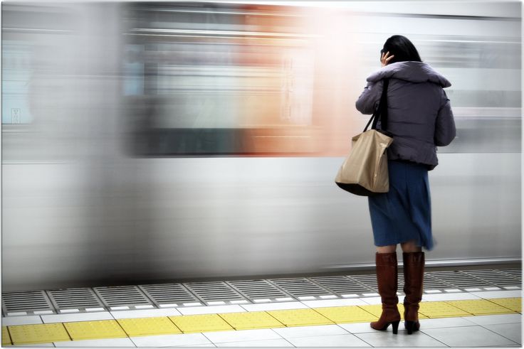 a woman waiting for the subway to stop