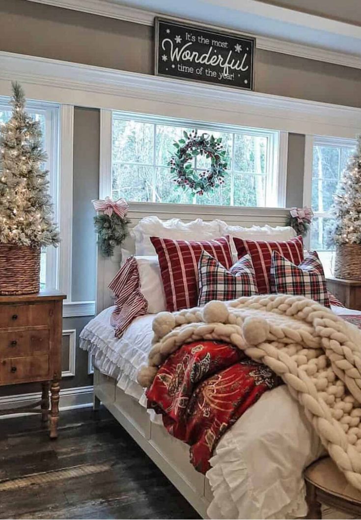 a large bed sitting in a bedroom next to a window with christmas decorations on it