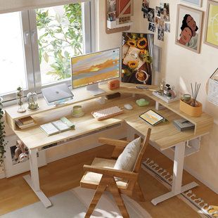 a computer desk sitting next to a window in a room with pictures on the wall