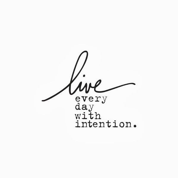 the words live every day with intention written in cursive writing