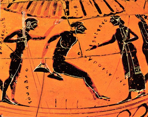 an orange vase with some black designs on it's side and two men running