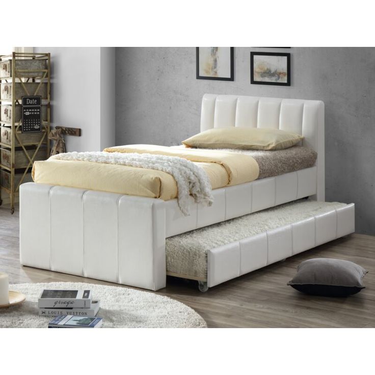 a white bed sitting on top of a wooden floor