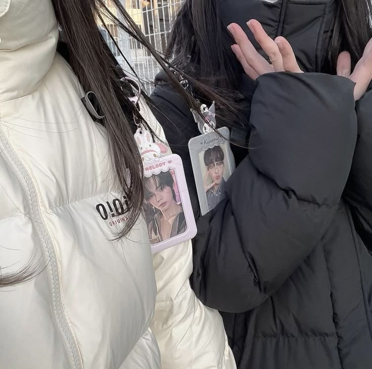 two women standing next to each other wearing jackets