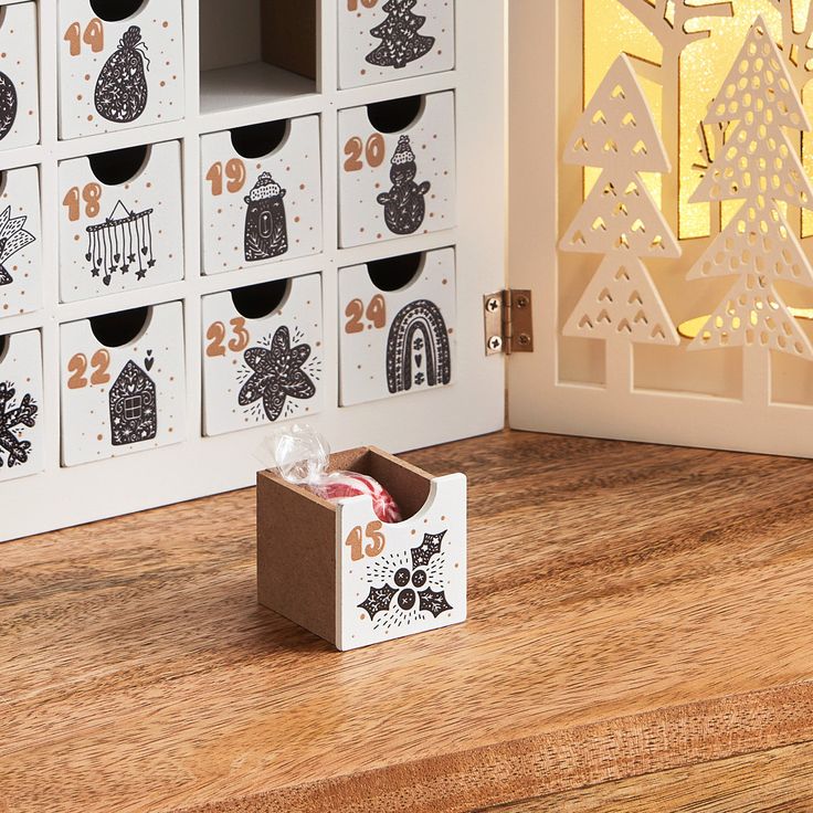 an open box sitting on top of a wooden table next to a wall with christmas decorations