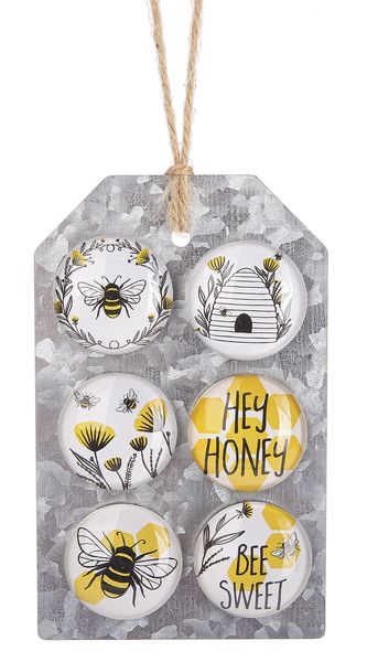 four buttons with bees on them and the words hey honey written in black ink, hanging from