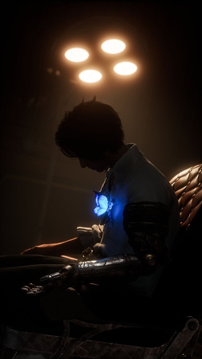 a man sitting in front of a laptop computer under three light bulbs on a dark background