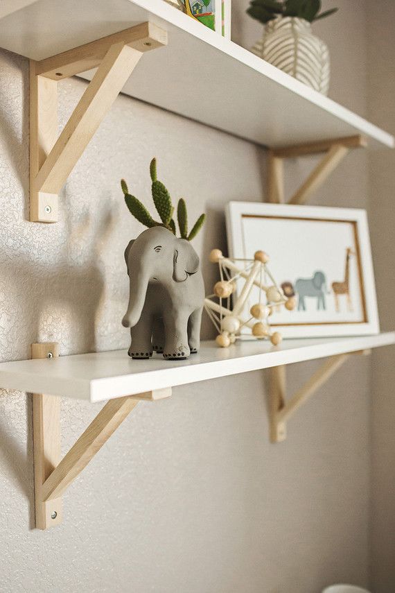 two wooden shelves with small figurines on them and an elephant statue in the middle