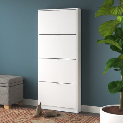 a white chest of drawers next to a plant in a living room with blue walls