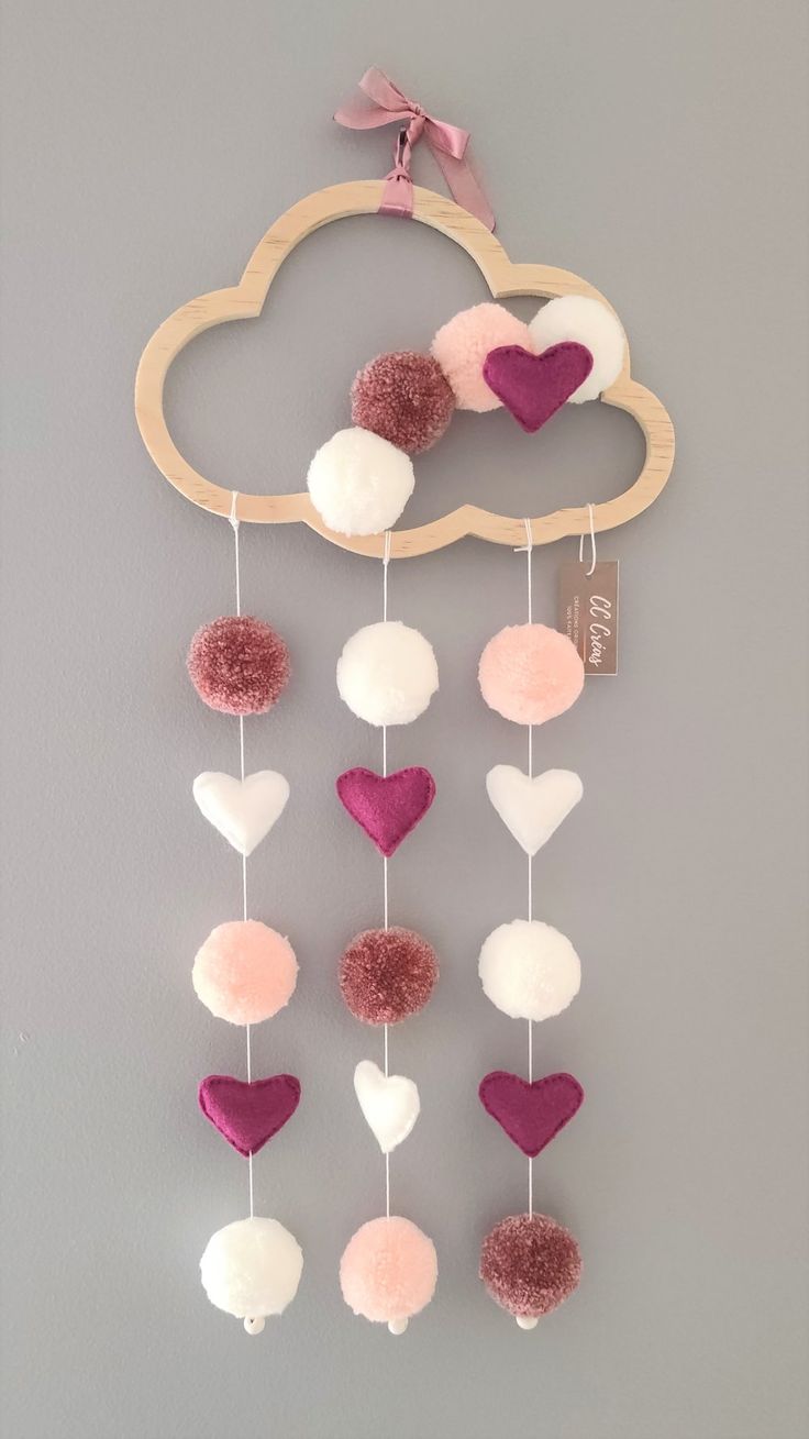 a pink and white cloud with hearts hanging from it