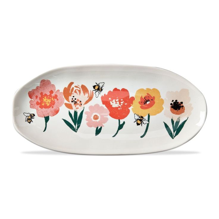 a white plate with flowers and bees painted on the side, in front of a white background