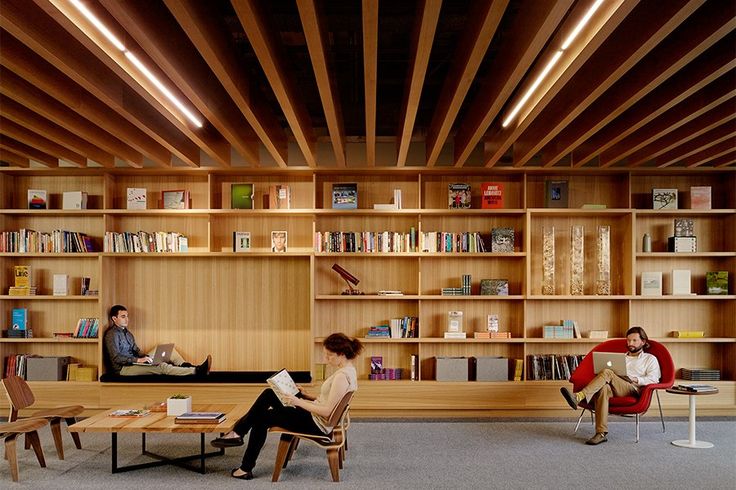 two people are sitting in chairs and reading books