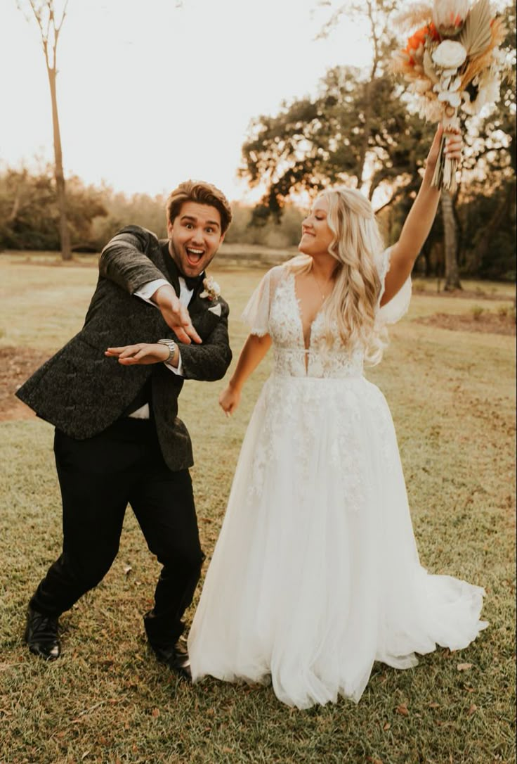 a bride and groom holding flowers in their hands