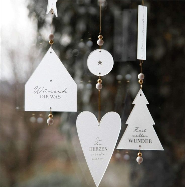 a wind chime hanging from the side of a window with christmas decorations on it