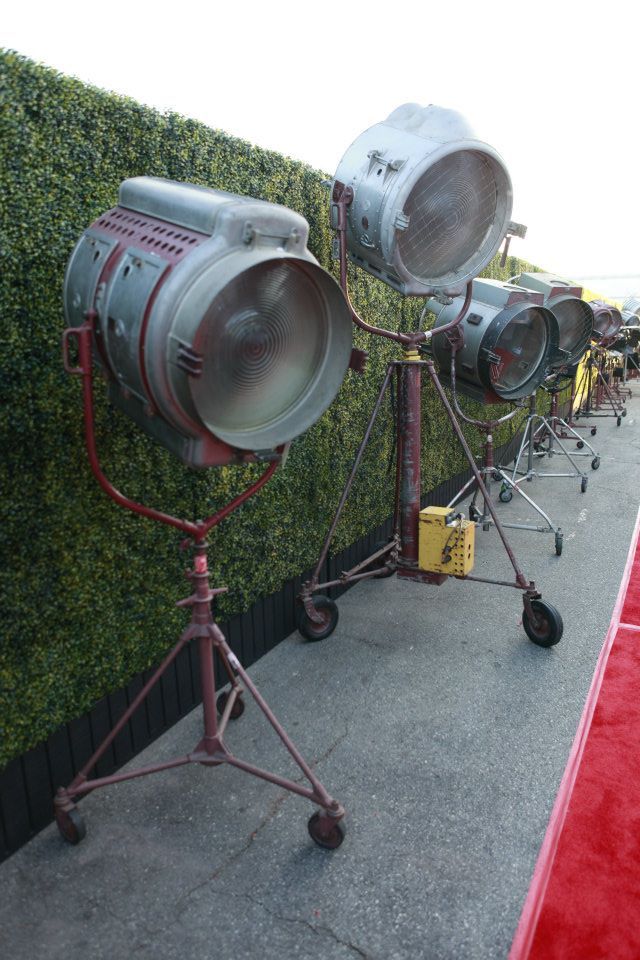 several spotlight lights are on top of a red carpeted area next to a green wall