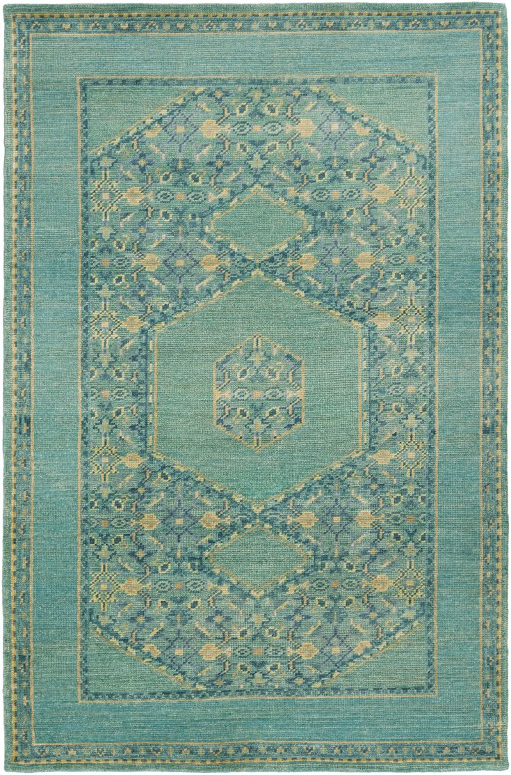 a green rug with an intricate design in the middle