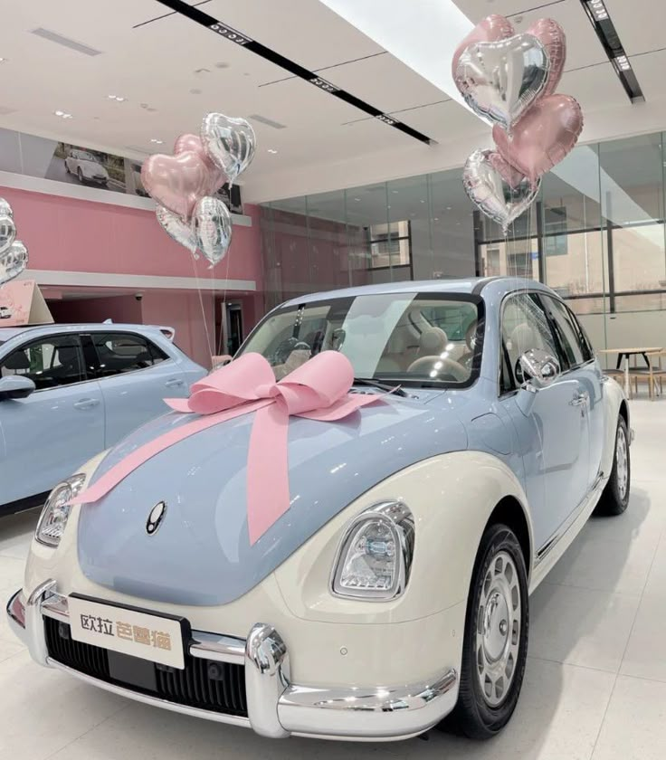 a car is decorated with pink and silver heart balloons for valentine's day in a showroom