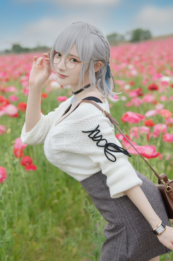 a woman with grey hair and glasses standing in a field of flowers holding a purse