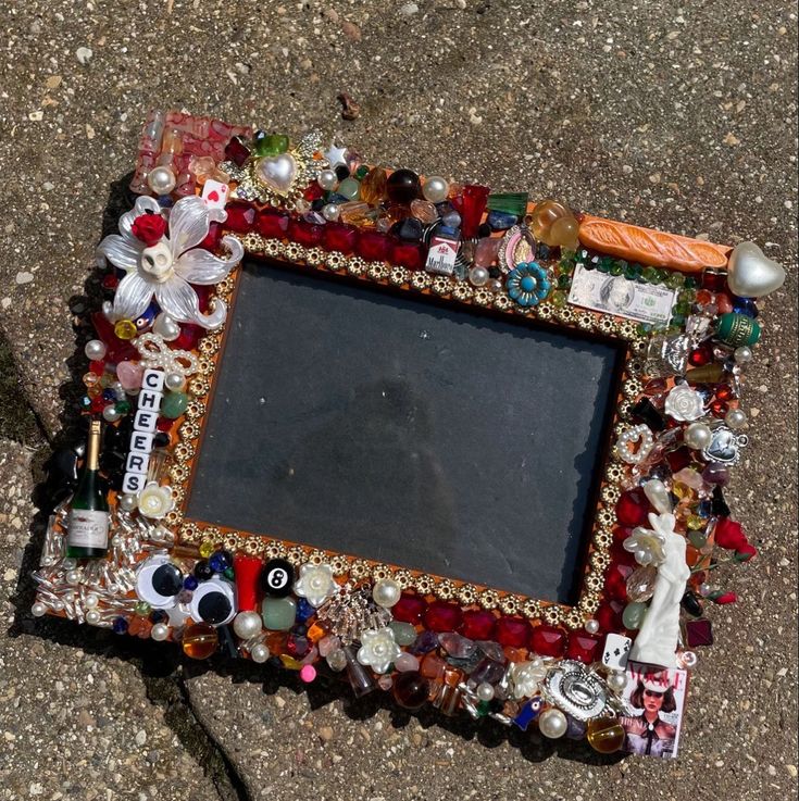 there is a photo frame with many different things in it on the ground next to a shoe