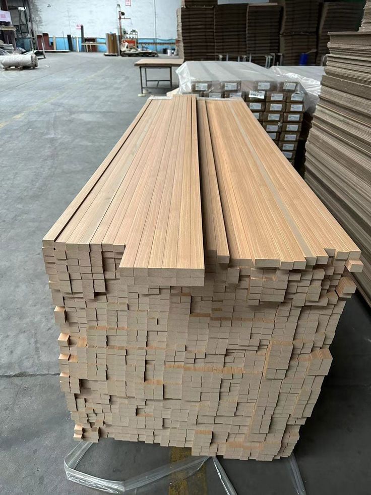 several stacks of wooden planks stacked on top of each other in a warehouse area