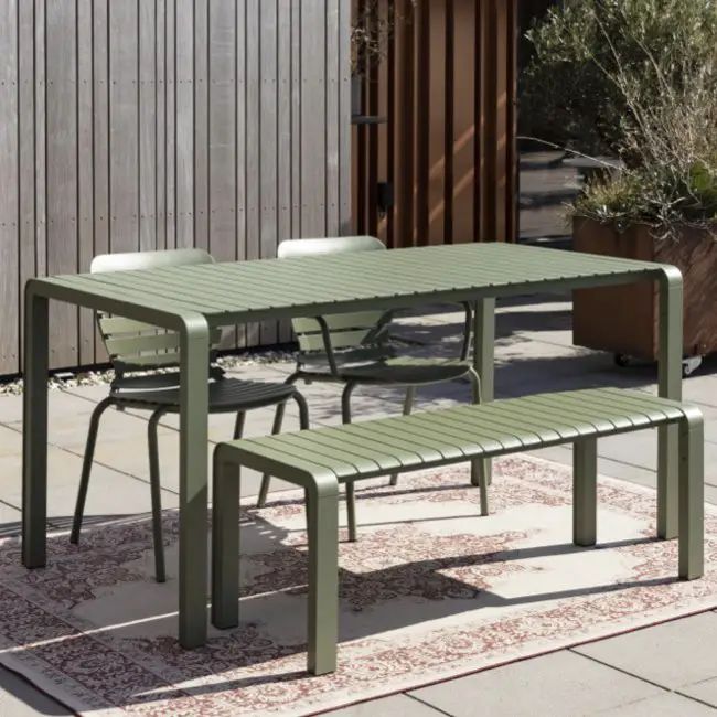 an outdoor table and two benches on a patio