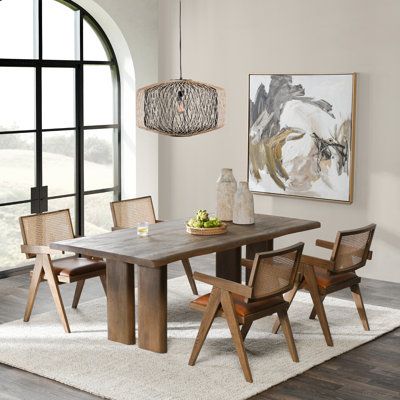 a dining room table and chairs in front of a large window