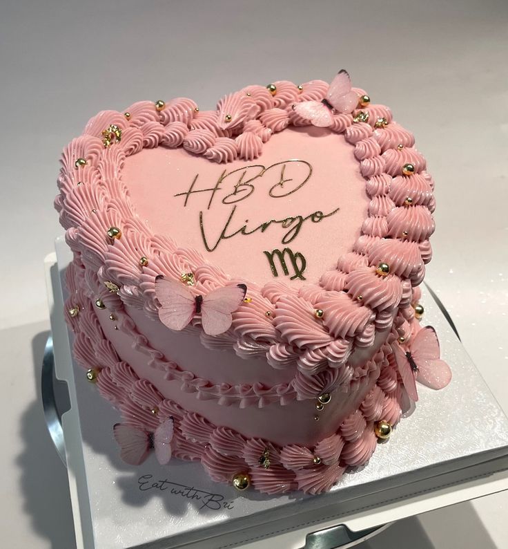 a pink heart shaped cake on top of a white plate with writing on the side