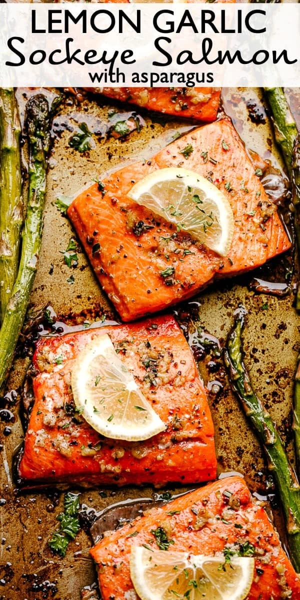 grilled salmon and asparagus on a baking sheet with lemons, herbs and seasonings