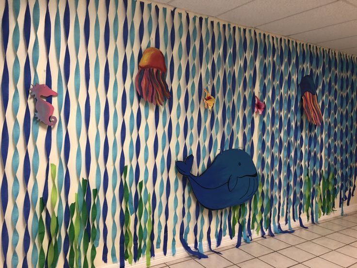 the wall is decorated with colorful fish and seaweed